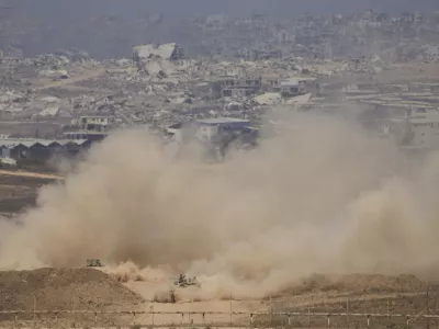 Israeli soldiers drive on their armored personnel carrier inside the northern Gaza Strip, as seen from southern Israel, Tuesday, July 29, 2025. (AP Photo/Ariel Schalit)