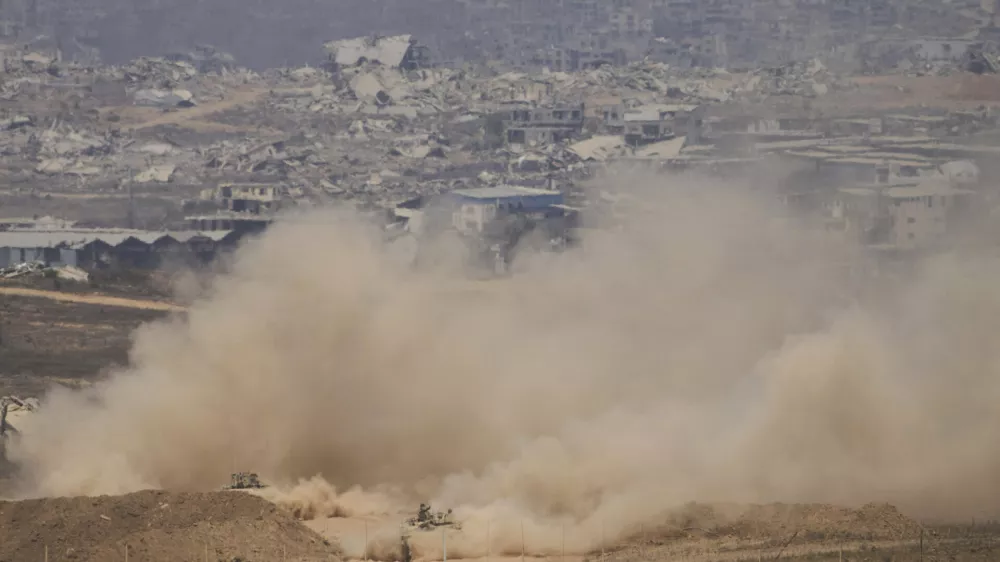 Israeli soldiers drive on their armored personnel carrier inside the northern Gaza Strip, as seen from southern Israel, Tuesday, July 29, 2025. (AP Photo/Ariel Schalit)