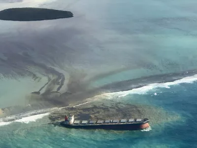 This photo taken and provided by Eric Villars shows oil leaking from the MV Wakashio, a bulk carrier ship that recently ran aground off the southeast coast of Mauritius, Friday, Aug. 7, 2020. Anxious residents of the Indian Ocean island nation of Mauritius are stuffing fabric sacks with sugar cane leaves to create makeshift oil spill barriers as tons of fuel leak from a grounded ship. The government has declared an environmental emergency and France says it is sending help from its nearby Reunion island. (Eric Villars via AP)
