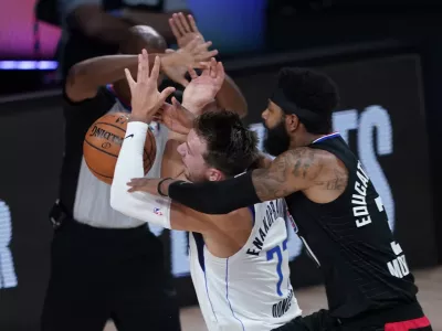 Dallas Mavericks' Luka Doncic (77) is fouled by Los Angeles Clippers' Marcus Morris Sr. during the first half of an NBA first round playoff game Sunday, Aug. 30, 2020, in Lake Buena Vista, Fla. (AP Photo/Ashley Landis)