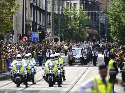 The funeral cortege of Black Sabbath frontman Ozzy Osbourne travels along Broad Street during his funeral procession, in Birmingham, England, Wednesday July 30, 2025. (Jacob King/PA via AP)