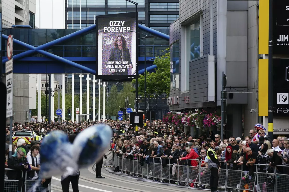 Fans gather Broad Street ahead of the funeral procession for Black Sabbath frontman Ozzy Osbourne following his death, in Birmingham, England, Wednesday July 30, 2025. (Jacob King/PA via AP)