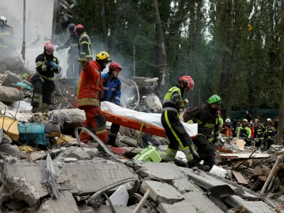 Rescuers carry a body at the site of an apartment building hit during Russian missile and drone strikes, amid Russia's attack on Ukraine, in Kyiv, Ukraine July 31, 2025. REUTERS/Thomas Peter