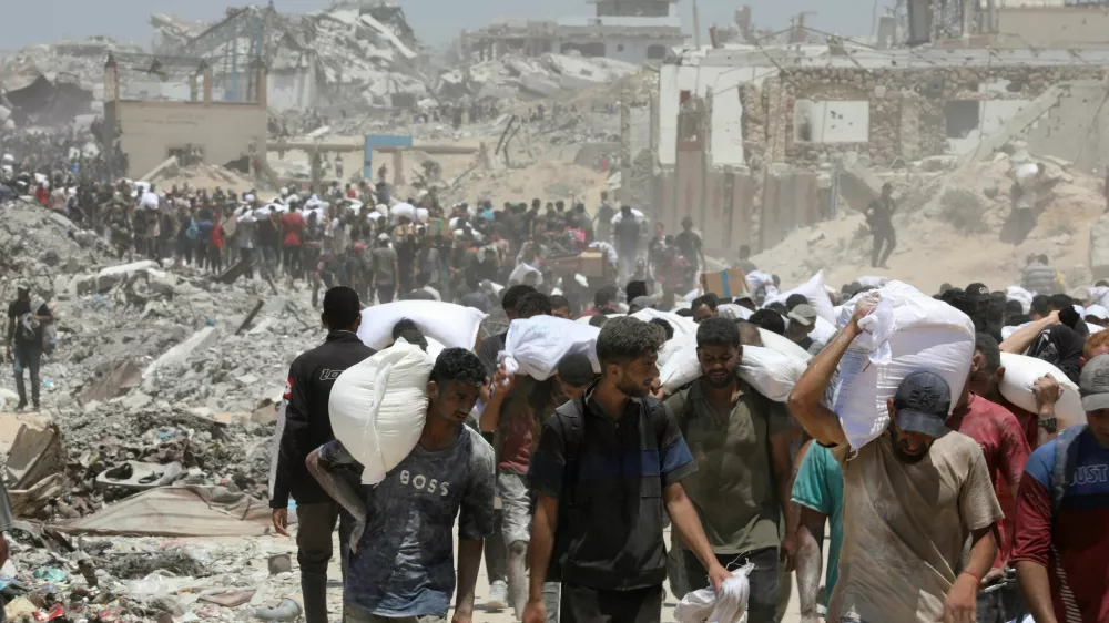 Palestinians carry aid supplies that entered Gaza through Israel, in Beit Lahia in the northern Gaza Strip, August 1, 2025. REUTERS/Dawoud Abu Alkas