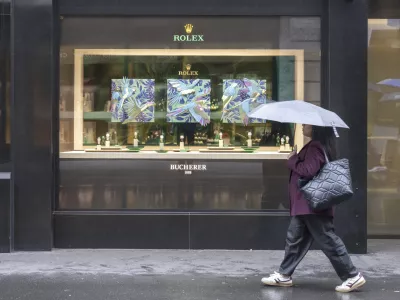 A woman walks by a store selling Rolex watches, on Grendelstrasse, Wednesday, April 16, 2025 in Lucerne, Switzerland. (Urs Flueeler/Keystone via AP)