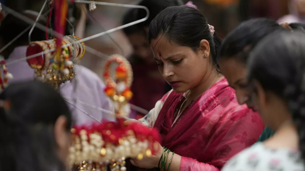 A woman shops for 'Rakhi,' the sacred thread symbolizing sibling bonds, ahead of the Raksha Bandhan festival in Jammu, India, Monday, Aug 4, 2025.(AP Photo/Channi Anand)