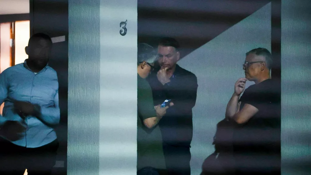 Brazil's former President Jair Bolsonaro talks to unidenfied people at his home after Brazil's Supreme Court put him under house arrest ahead of his trial for an alleged coup plot, in Brasilia, Brazil August 4, 2025. Pedro Ladeira/Folhapress via REUTERS ATTENTION EDITORS &ndash; THIS IMAGE HAS BEEN SUPPLIED BY A THIRD PARTY. NO RESALES. NO ARCHIVES. BRAZIL OUT. NO COMMERCIAL OR EDITORIAL SALES IN BRAZIL   TPX IMAGES OF THE DAY