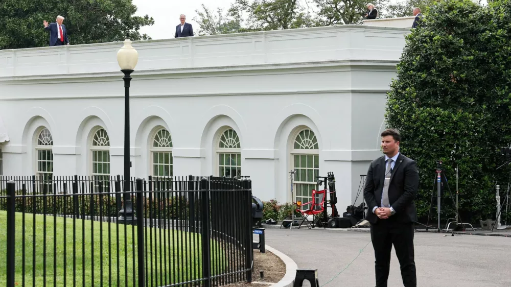 U.S. President Donald Trump waves from the roof as he gets a different view of the site of the proposed ballroom, at the White House in Washington, D.C., U.S., August 5, 2025. REUTERS/Jessica Koscielniak   TPX IMAGES OF THE DAY