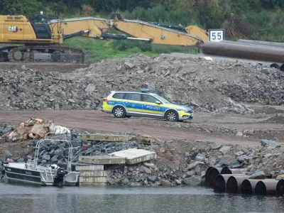 05 August 2025, Saxony, Dresden: A police vehicle stands on the construction site at the demolished Carola Bridge on the Neustadt side of the Elbe. Another bomb from the Second World War has been found during clearance work on the former Elbe crossing. Photo: Sebastian Kahnert/dpa