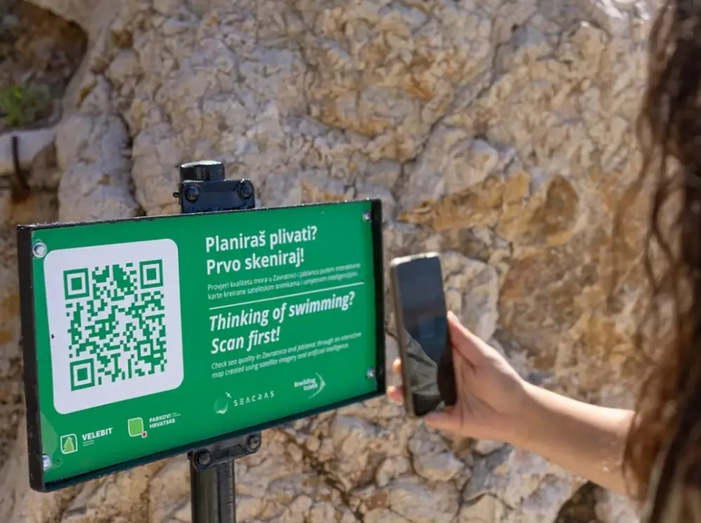  Na informativnih tablah ob uvali in v bližnjem Jablancu lahko obiskovalci s skeniranjem QR kode preverijo trenutno kakovost morja. F SeaCras i