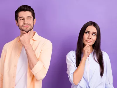 Photo of unsure funny husband wife dressed shirts looking empty space arm chin isolated purple color background. / Foto: Deagreez