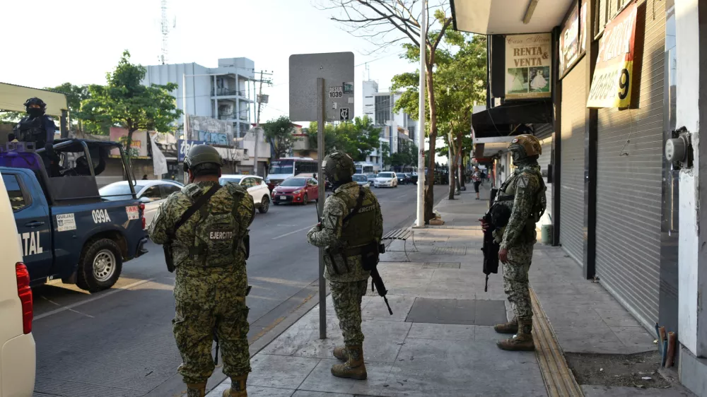 Members of the federal forces operate near a business closed and put up for rent, as violence and economic turmoil escalate in Culiacan one year after the abduction and extradition of Sinaloa Cartel leader Ismael "El Mayo" Zambada to the United States, in Culiacan, Sinaloa state, Mexico, July 24, 2025. REUTERS/Fernando Brito