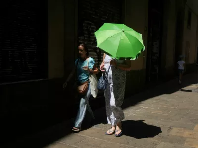 A woman carries an umbrella for shade from the heat as she walks around El Born, in Barcelona, Spain, August 9, 2025. REUTERS/Bruna Casas / Foto: Bruna Casas