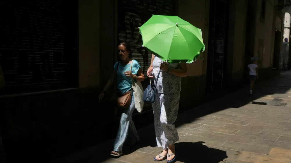 A woman carries an umbrella for shade from the heat as she walks around El Born, in Barcelona, Spain, August 9, 2025. REUTERS/Bruna Casas / Foto: Bruna Casas