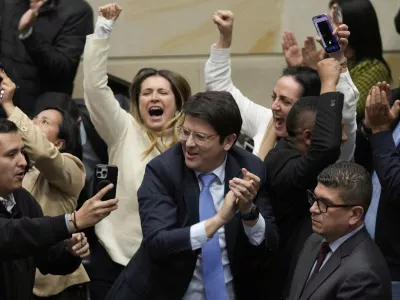 FILE - Miguel Uribe Turbay, center in blue tie, a Colombian senator and presidential candidate for the right-wing Centro Democr&aacute;tico party, celebrates after voting against a labor reform referendum proposed by the government, in Bogota, Colombia, May 14, 2025. (AP Photo/Fernando Vergara, File)