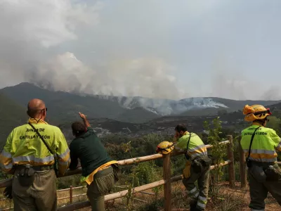 Firefighters wait for orders for deployment while monitoring a wildfire in the area of Voces from a viewpoint in Orellan, Spain, August 11, 2025. REUTERS/Violeta Santos Moura