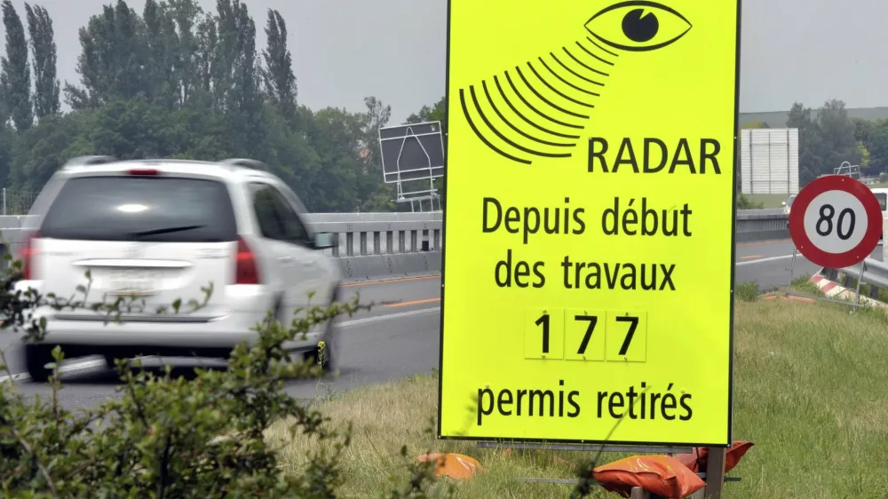 FILE - A vehicle passes in front of a sign of the Vaud Cantonal Police indicating the number of driving licences withdrawn for speeding in the construction zone on the A1 motorway between Lausanne and Yverdon, Switzerland, Tuesday, June 15, 2010. (Dominic Favre/Keystone via AP, file)