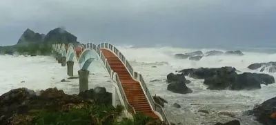 In this image made from video released by Taitung County Government, strong waves and heavy rain pound the Sansiiantai tourist spot on Aug. 13, 2025, as Typhoon Podul reaches Taitung, eastern Taiwan. (Taitung County Government via AP)