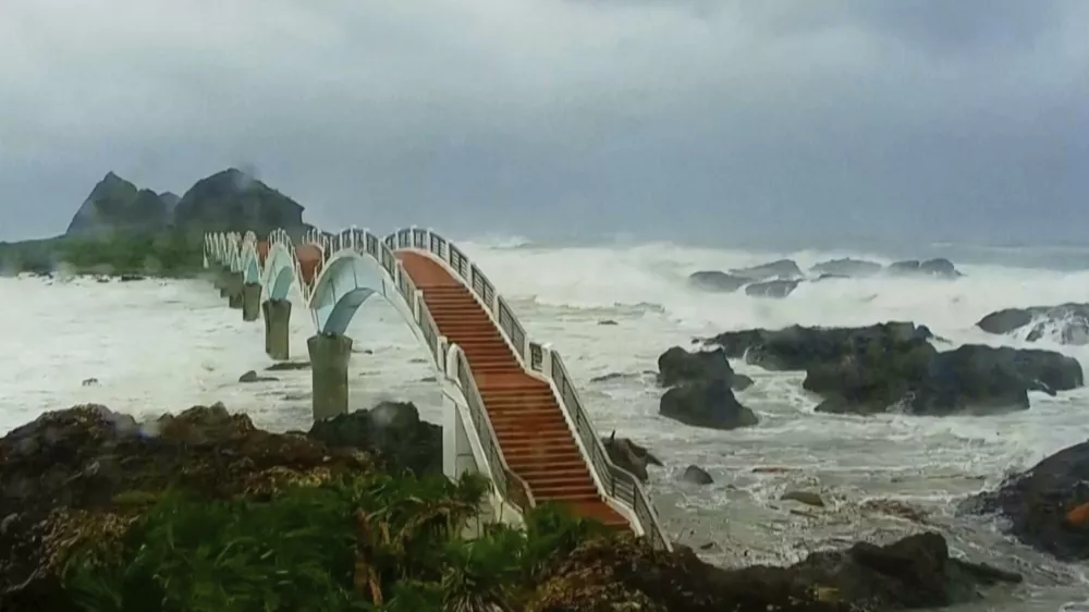 In this image made from video released by Taitung County Government, strong waves and heavy rain pound the Sansiiantai tourist spot on Aug. 13, 2025, as Typhoon Podul reaches Taitung, eastern Taiwan. (Taitung County Government via AP)