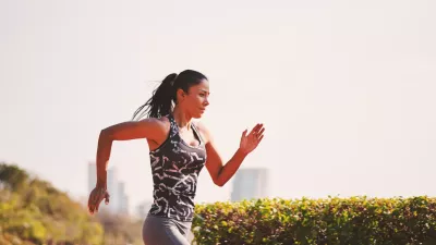 Sport girl in sporty outfit running at the lane in the park