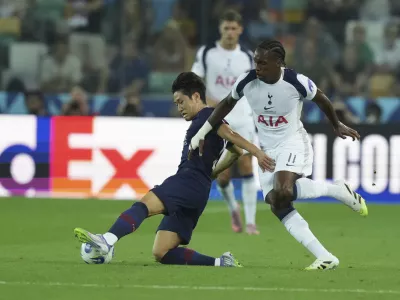 PSG's Kang-in Lee, left, and Tottenham's Mathys Tel challenge for the ball during the UEFA Super Cup soccer match between Paris Saint-Germain and Tottenham Hotspur in Udine, Italy, Wednesday, Aug. 13, 2025. (AP Photo/Antonio Calanni)