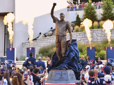A bronze statue of former New England Patriots quarterback Tom Brady is unveiled in Patriot Place Plaza before an NFL preseason football game between the Washington Commanders and the New England Patriots Friday, Aug. 8, 2025, in Foxborough, Mass. (AP Photo/Steven Senne)