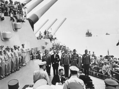 FILE- In this Sept. 2, 1945, file photo, then Japanese Foreign Minister Mamoru Shigemitsu signs Japanese Instrument of Surrender, a document signed on the deck of the USS Missouri in Tokyo Bay, Japan. (Pool Photo via AP, File)
