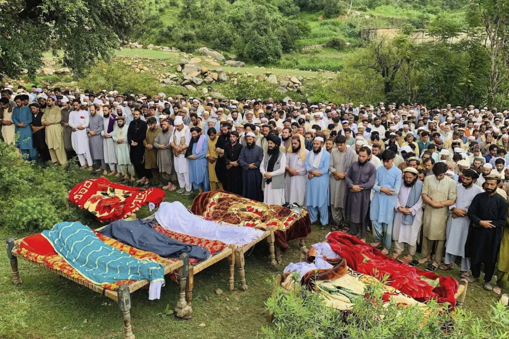 People attend funeral prayers of the victims of cloudburst incident, in Salarzai, Pakistan, Friday, Aug. 15, 2025. (AP Photo/Anwarullah Khan)