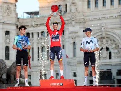 Cycling - Vuelta a Espana - Stage 21 - Madrid to Madrid - Spain - September 8, 2024 Red Bull - Bora - Hansgrohe's Primoz Roglic celebrates on the podium with a trophy after winning the Vuelta a Espana with second placed Decathlon AG2R La Mondiale Team's Ben O'connor and third placed Movistar Team's Enric Mas REUTERS/Isabel Infantes