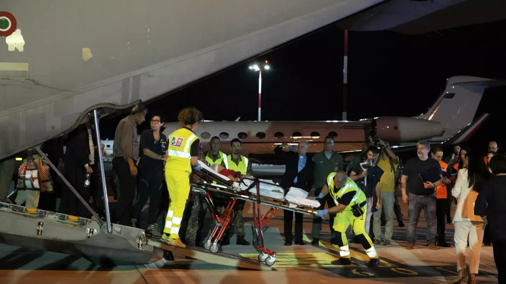 Palestinian children and their families evacuated from Gaza arrive at Rome's Ciampino military airport, Thursday, Aug. 14, 2025. (AP Photo/Gregorio Borgia)
