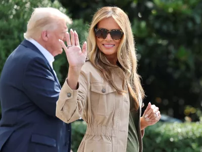 FILE PHOTO: First lady Melania Trump waves as she walks with U.S. President Donald Trump before they depart for travel to Texas to tour areas affected by deadly flash flooding, from the South Lawn of the White House in Washington, D.C., U.S., July 11, 2025. REUTERS/Jonathan Ernst/File Photo