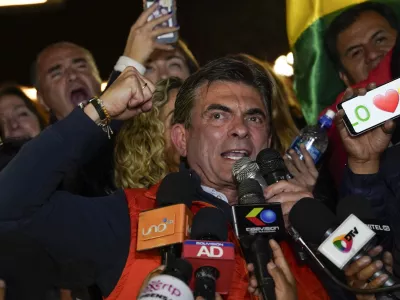 Presidential candidate Rodrigo Paz, center, addresses supporters after early results showed him leading in the presidential election in La Paz, Bolivia, Sunday, Aug. 17, 2025. (AP Photo/Freddy Barragan)