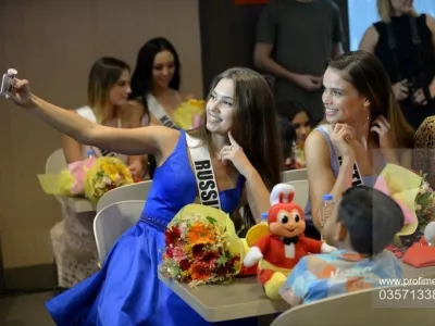 (From L to R) Miss Universe contestants Kseniya Alexandrova of Russia, Nicky Opheij of the Netherlands and Samantha James of Malaysia take a selfie with children from an orphanage during a visit to a popular fast food restaurant in Manila on December 7, 2017. Miss Universe Demi-Leigh Nel-Peters of South Africa and other pageant contestants are in Manila for a visit after the contest in Las Vegas last month.,Fotografija:357133851, Licenca:Rights-managed, Omejitve:, Model izdaje:no