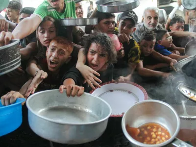 FILE PHOTO: Palestinians gather to receive food cooked by a charity kitchen, amid the Israel-Hamas conflict, in the northern Gaza Strip, September 11, 2024. REUTERS/Mahmoud Issa/File Photo