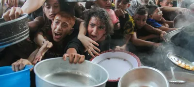FILE PHOTO: Palestinians gather to receive food cooked by a charity kitchen, amid the Israel-Hamas conflict, in the northern Gaza Strip, September 11, 2024. REUTERS/Mahmoud Issa/File Photo