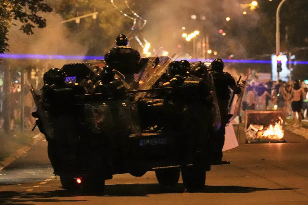 Serbian gendarmerie officers chase protesters during an anti-government protest in Belgrade, Serbia, Monday, Aug. 18, 2025. (AP Photo/Darko Vojinovic)