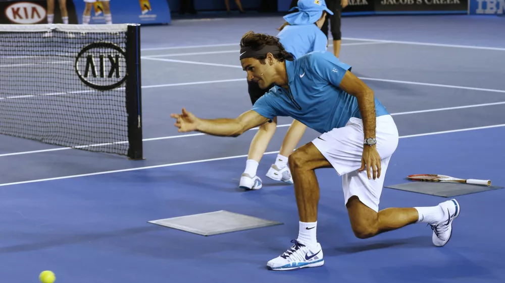 Switzerland's Roger Federer throws the ball along the court as he acts as a ball boy during an exhibition match during the Kids Tennis Day at Melbourne Park ahead of the Australian Open tennis championship in Melbourne, Australia, Saturday, Jan. 12, 2013. (AP Photo/Andy Wong)