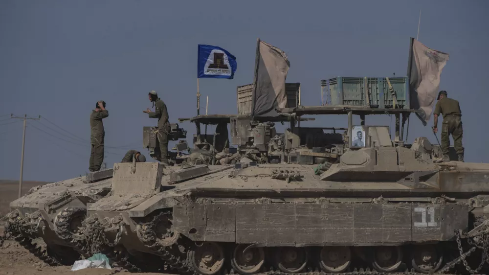 Israeli soldiers stand on the top of armoured vehicles parked on an area near the Israeli-Gaza border, as seen from southern Israel, Wednesday, Aug. 20, 2025. (AP Photo/Maya Levin)