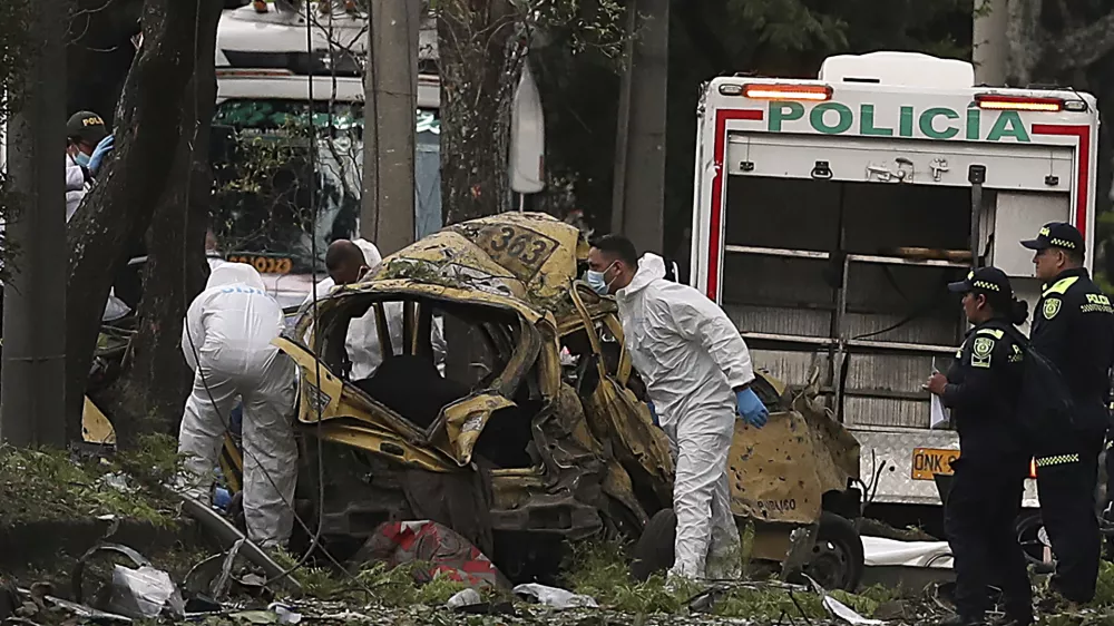 Forensics inspect the site of a bomb explosion outside an Air Force base in Cali, Colombia, Thursday, Aug. 21, 2025. (AP Photo/Santiago Saldarriaga)