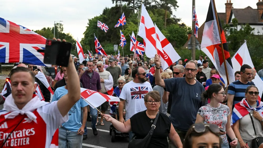 Protesters take part in an anti-immigration demonstration, following Tuesday's High Court ruling in London that granted a temporary injunction to stop asylum seekers from being housed at the The Bell Hotel, in Epping, Britain, August 24, 2025. REUTERS/Jaimi Joy