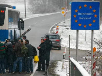 Migrants walk during snowfall before passing Austrian-German border in Wegscheid in Austria, near Passau November 22, 2015. REUTERS/Michael Dalder - RTX1VA39