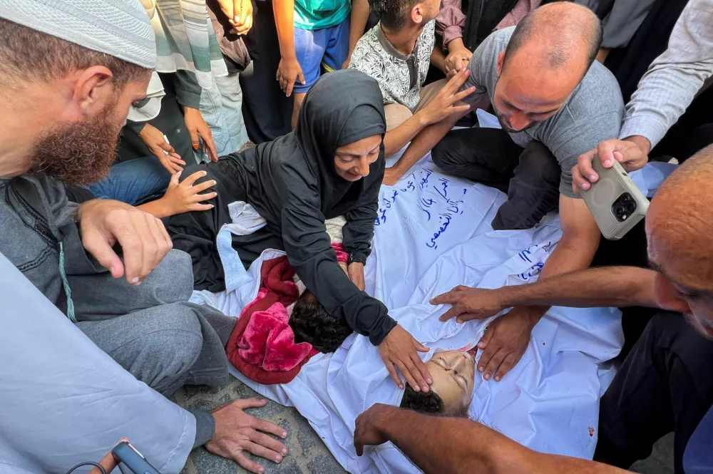 SENSITIVE MATERIAL. THIS IMAGE MAY OFFEND OR DISTURB Mourners gather around the body of a Palestinian, during the funeral of Palestinians killed in an Israeli strike on a tent camp, at Nasser hospital in Khan Younis, in the southern Gaza Strip August 23, 2025. REUTERS/Hussam Al-Masri