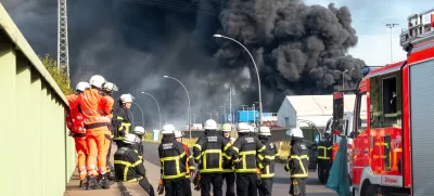 25 August 2025, Hamburg: Emergency services prepare for their deployment to extinguish a major fire in a warehouse in Hamburg. A fire has broken out in a warehouse in the Port of Hamburg, causing a major motorway nearby to be closed. Photo: Bodo Marks/dpa