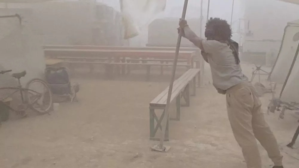 A man holds up a tent structure amid a dust storm near Burning Man festival's Black Rock Desert site, a day before the annual festival's start, in Gerlach, Nevada, U.S., August 23, 2025, in this still image obtained from a social media video. Simba Khela/via REUTERS THIS IMAGE HAS BEEN SUPPLIED BY A THIRD PARTY. NO RESALES. NO ARCHIVES. MANDATORY CREDIT. VERIFICATION: Reuters was able to confirm the location of the video from corroborating footage posted on social media. Date of footage was confirmed on file data. National Weather Service (NWS) said in a statement that there was dust storm 9 miles northwest of Lovelock 23 August (Saturday). Burning Man event starts on August 24 in Black Rock Desert.