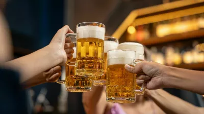 Close-up Group of People Holding Beer and Cheer in Restaurant. They Enjoying with Night Party Together. Party, Lifestyle, Happiness, Cheerful and Celebration Concept.