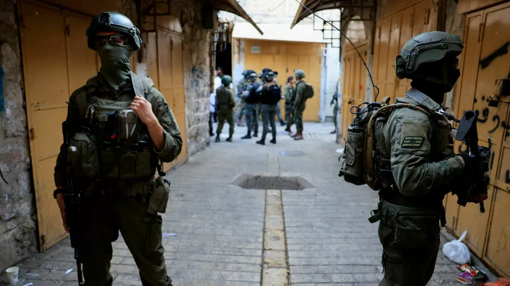 Israeli troops stand guard during a weekly settlers' tour in Hebron, in the Israeli-occupied West Bank, August 30, 2025. REUTERS/Mussa Qawasma