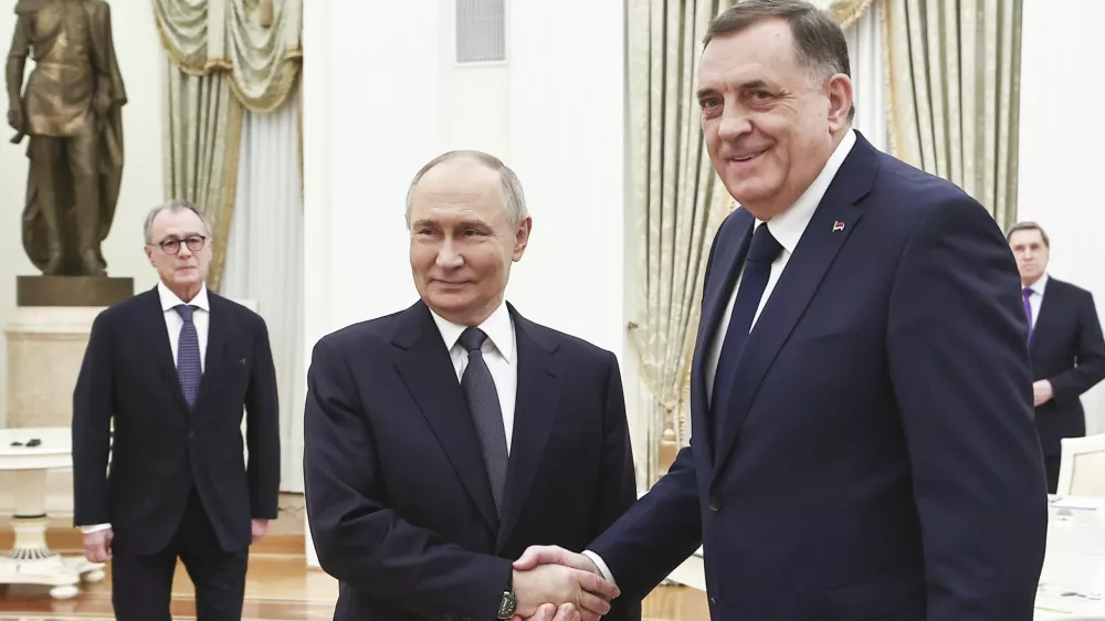 Russian President Vladimir Putin, center, and Bosnian Serb President Milorad Dodik shake hands during their meeting at the Kremlin in Moscow, Russia, Tuesday, April 1, 2025. (Mikhail Tereshchenko, Sputnik, Kremlin Pool Photo via AP)