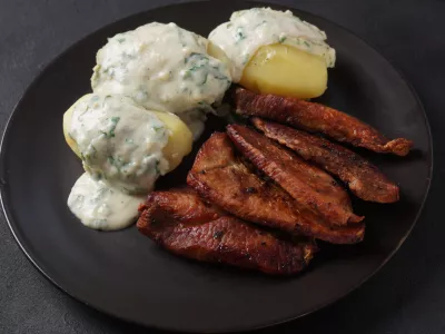 Crispy fried pork with creamy parsley sauce and boiled potato in the plate on the table or stegt fl&aelig;sk, a classic Danish cuisine. / Foto: Nataly Hanin