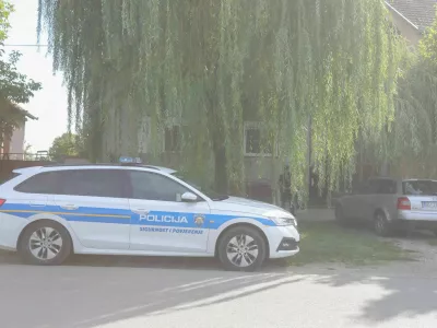 Policijski avto pred hi&scaron;o, v greznici katere naj bi na&scaron;li truplo pogre&scaron;ane ženske. 