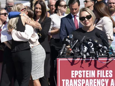 Anouska de Georgiou, left, hugs Marina Lacerda as Courtney Wild, right, speaks during a news conference at the U.S. Capitol, Wednesday, Sept. 3, 2025, in Washington. (AP Photo/Jose Luis Magana)
